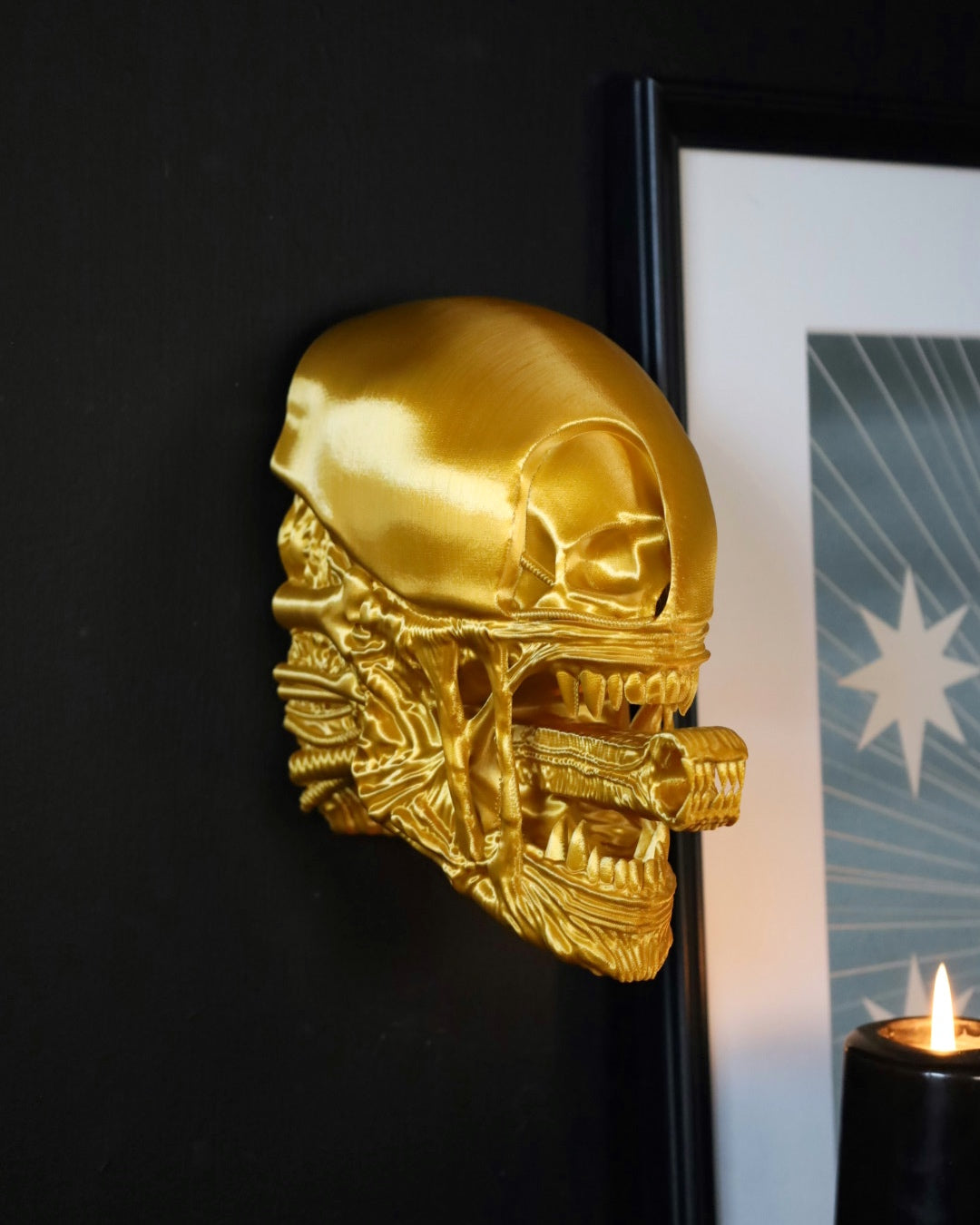 A gold 3D printed wall hanging depicting a a xenomorph from the horror movie aliens