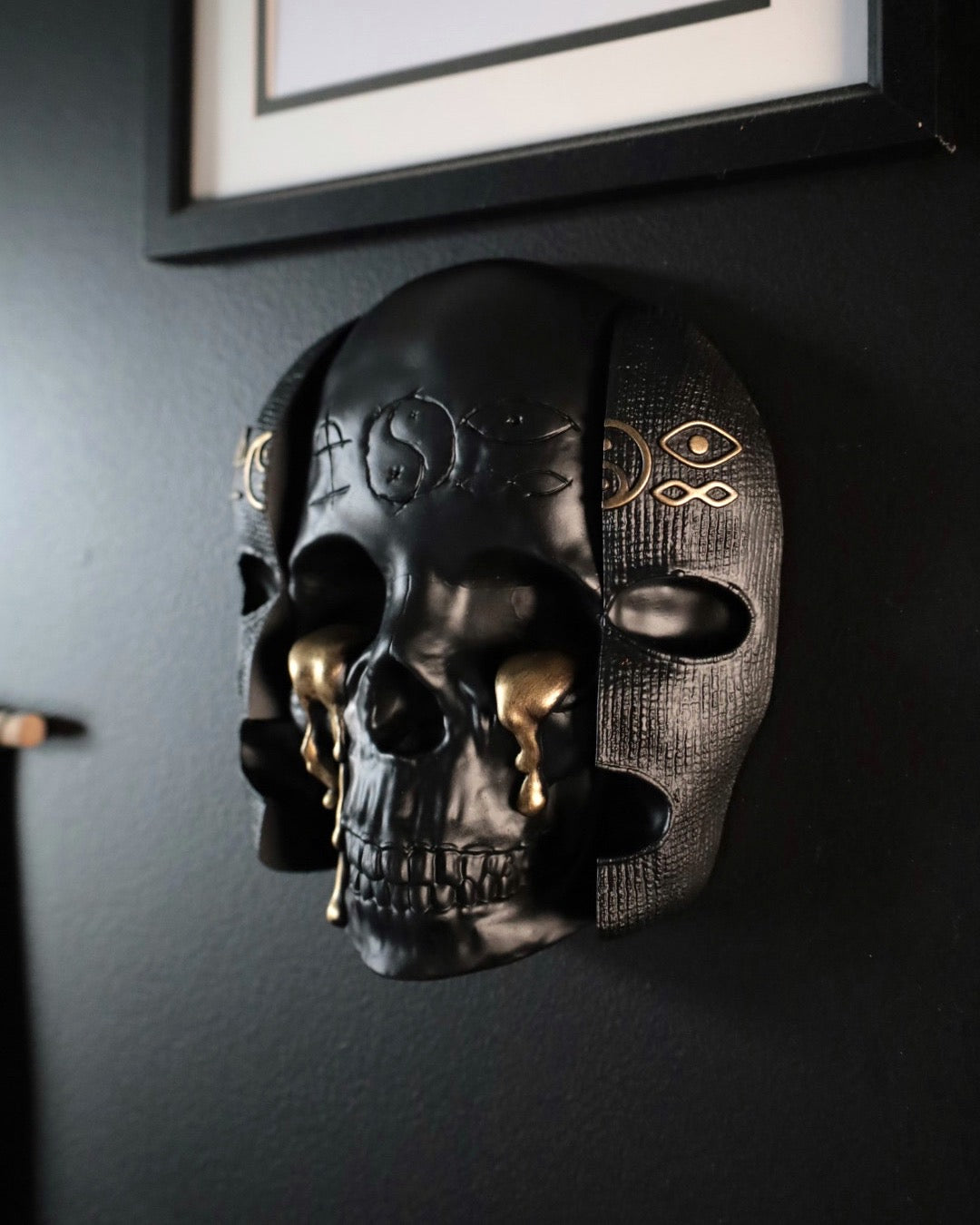 Decorative skull wall art with gold accents on a dark wall inspired by Bad Omens 