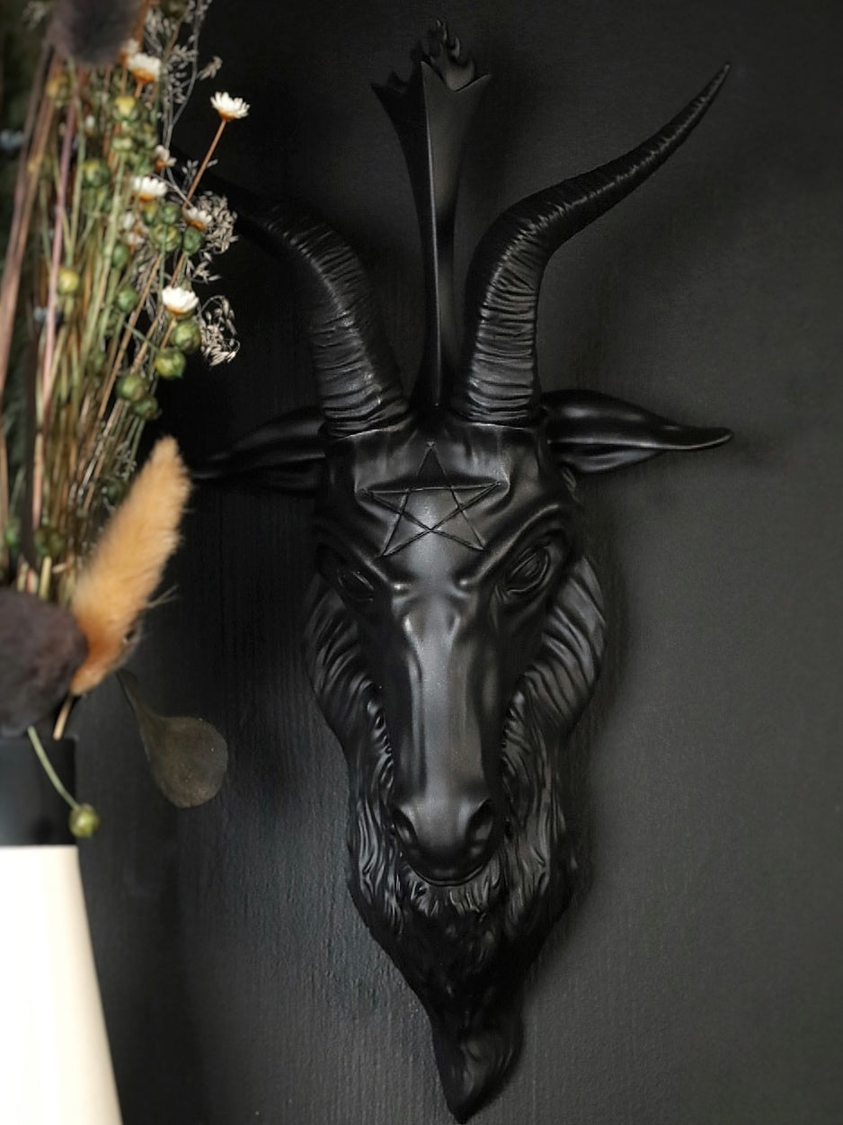 Black goat head wall decoration on a dark background