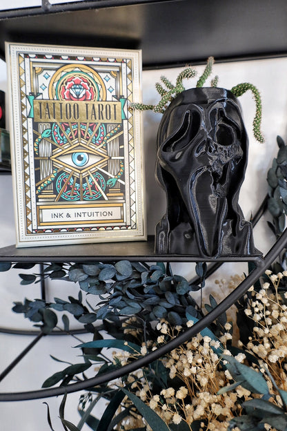 Framed tattoo tarot card on a shelf with decorative elements