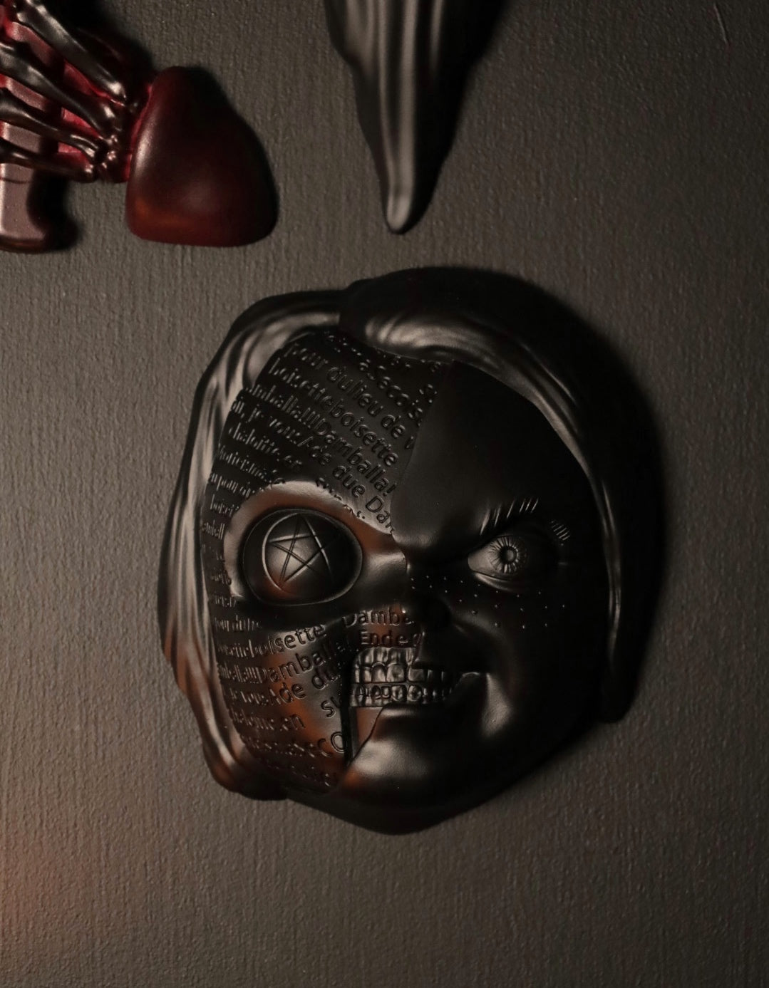 Close up of Chucky wall hanging from the movie Childs Play with the spell. 