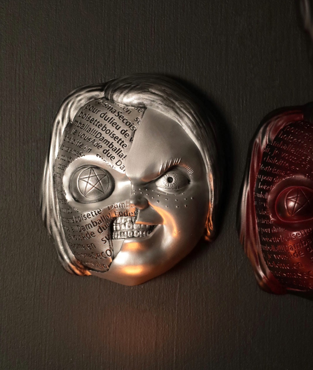 Close up of Chucky wall hanging from the movie Childs Play with the spell. 