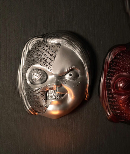 Close up of Chucky wall hanging from the movie Childs Play with the spell. 