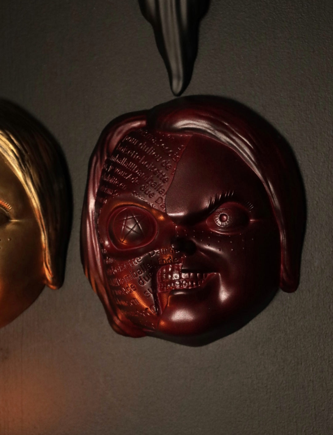 Close up of Chucky wall hanging from the movie Childs Play with the spell. 