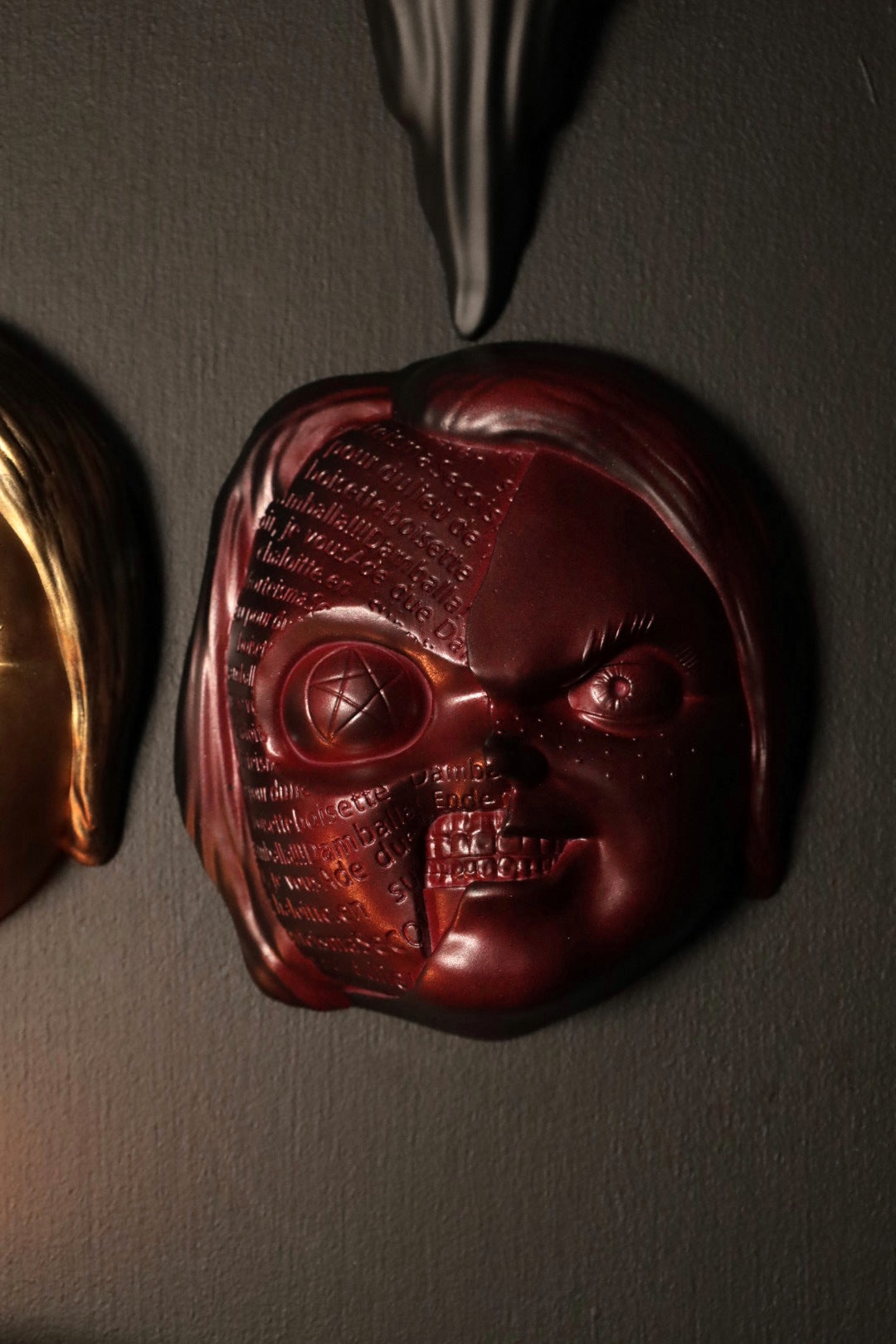 Close up of Chucky wall hanging from the movie Childs Play with the spell. 