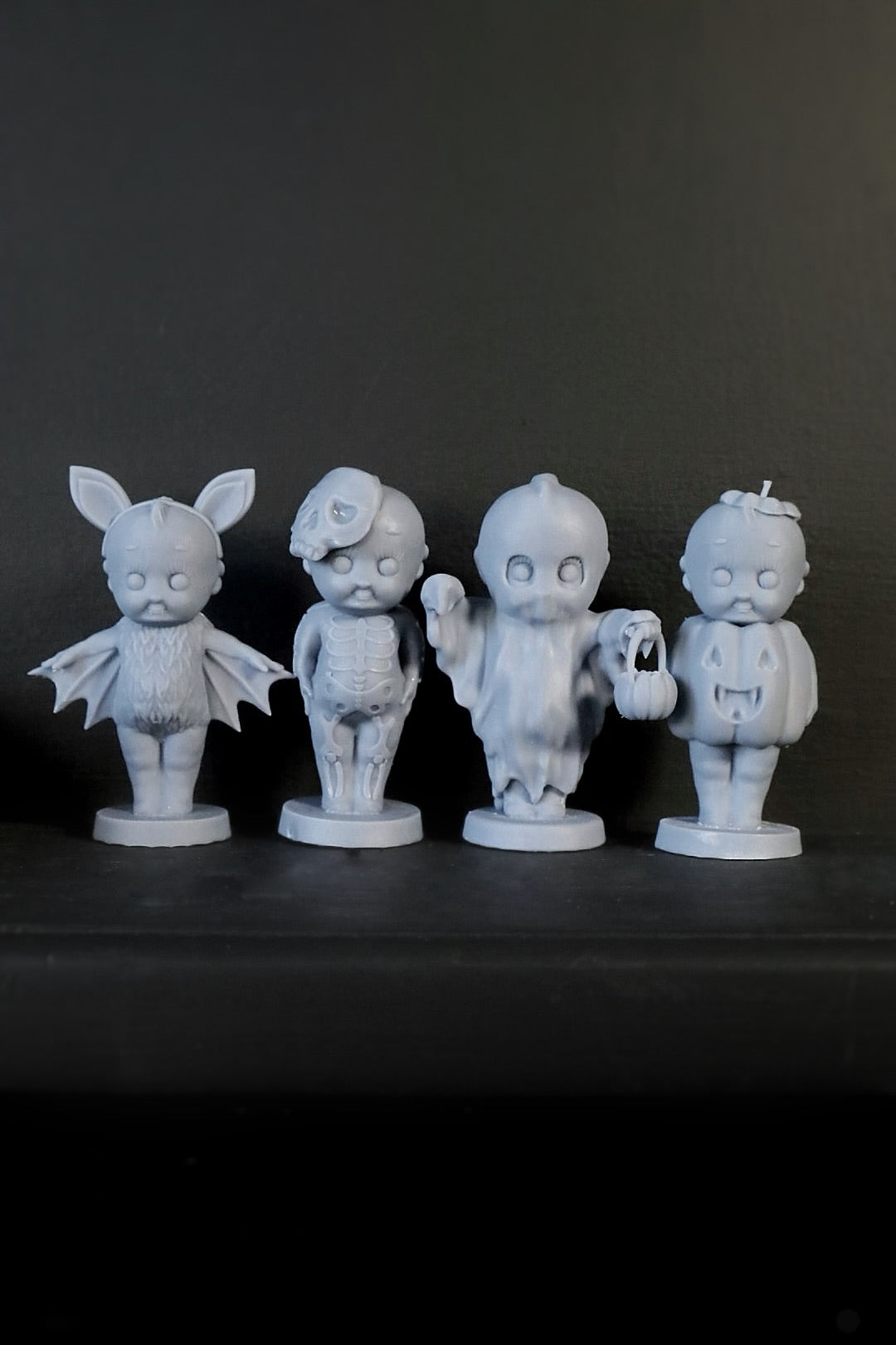 A set of four Kreepy gothic ornaments including designs that resemble a bat, pumpkin, ghost, and skeleton. 