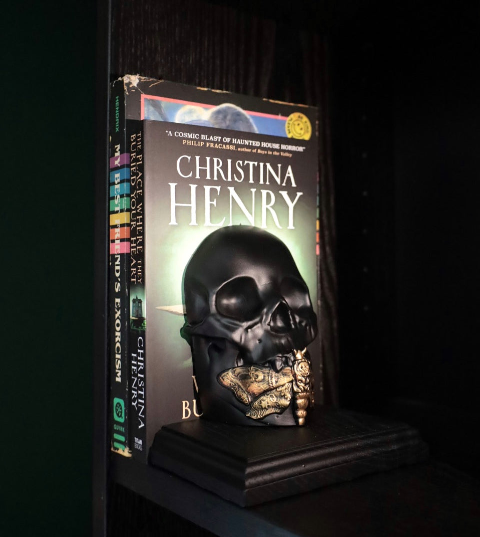 A death moth skull bookend in black and gold.