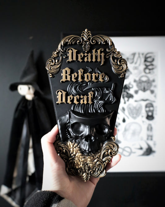 Decorative wall hanging with 'Death Before Decaf' text and skull design