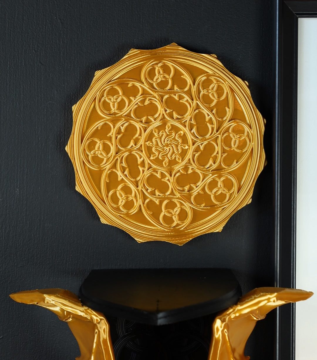 Gold wall decor featuring a snake gothic design. 