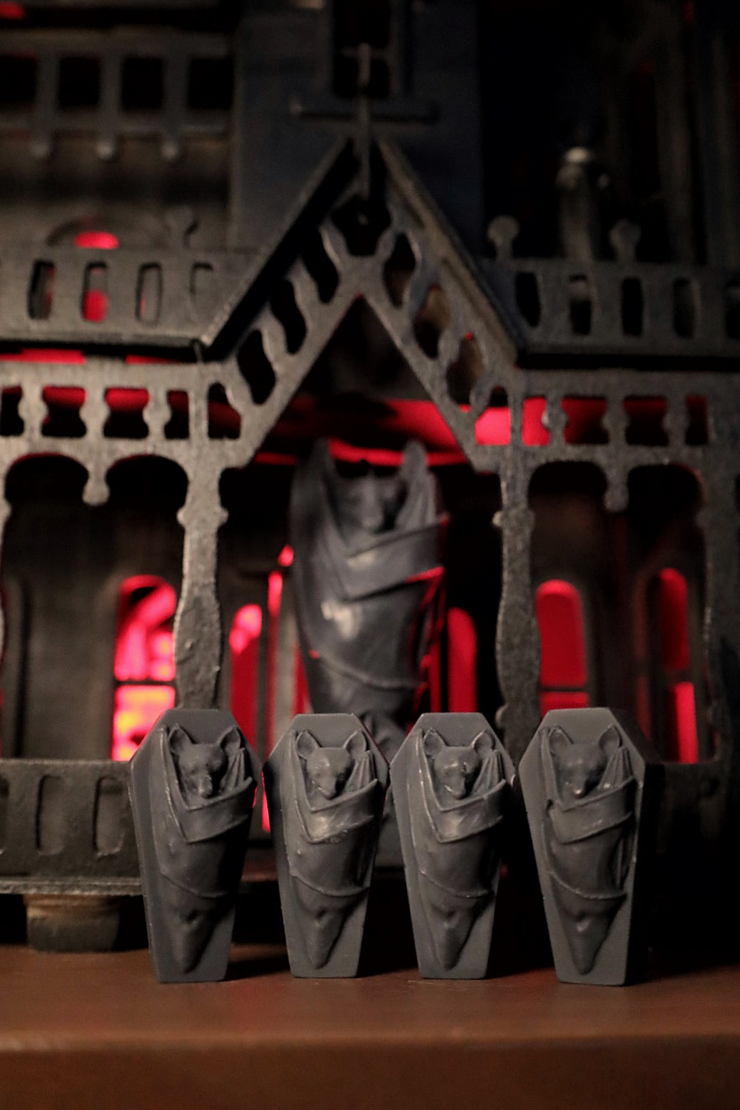 Four gothic black bat wax melts on a coffin background. Great gifts for goths.
