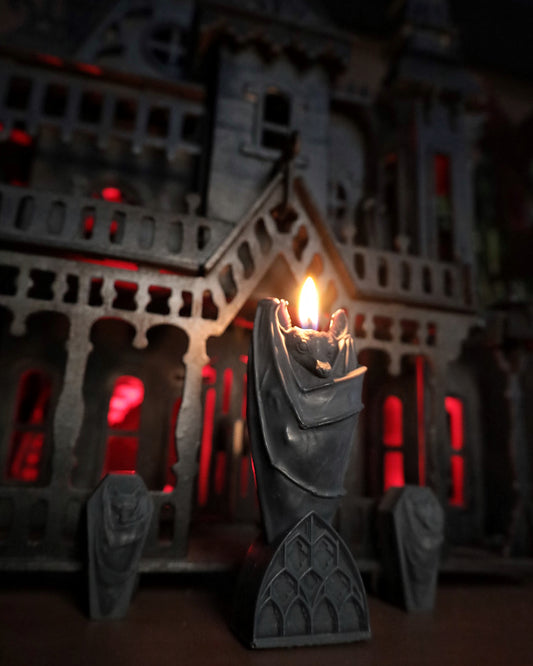 A bat candle featuring gothic black architecture 