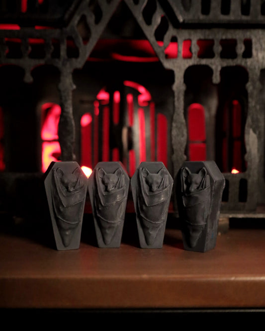 Four gothic black bat wax melts on a coffin shape background. The perfect gift for goths or a great gothic home accent.