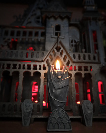 Gothic home decor featuring a gothic black bat candle on gothic architecture.