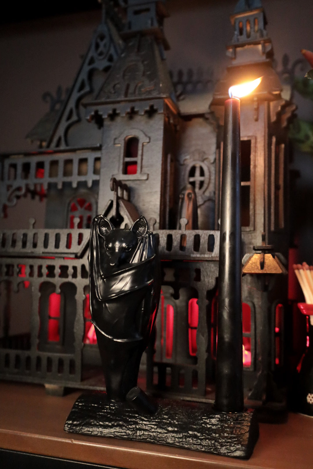 A gothic home decoration piece featuring a gothic black bat on a candle holder 