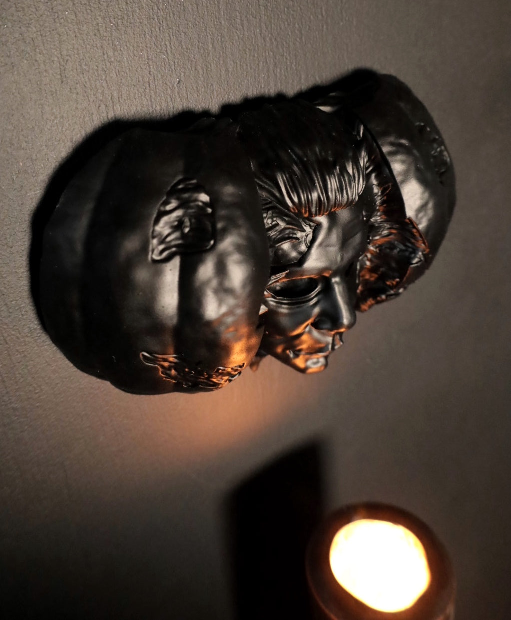 Hand holding a Halloween pumpkin with a Michael Myers face mask inside against a dark background