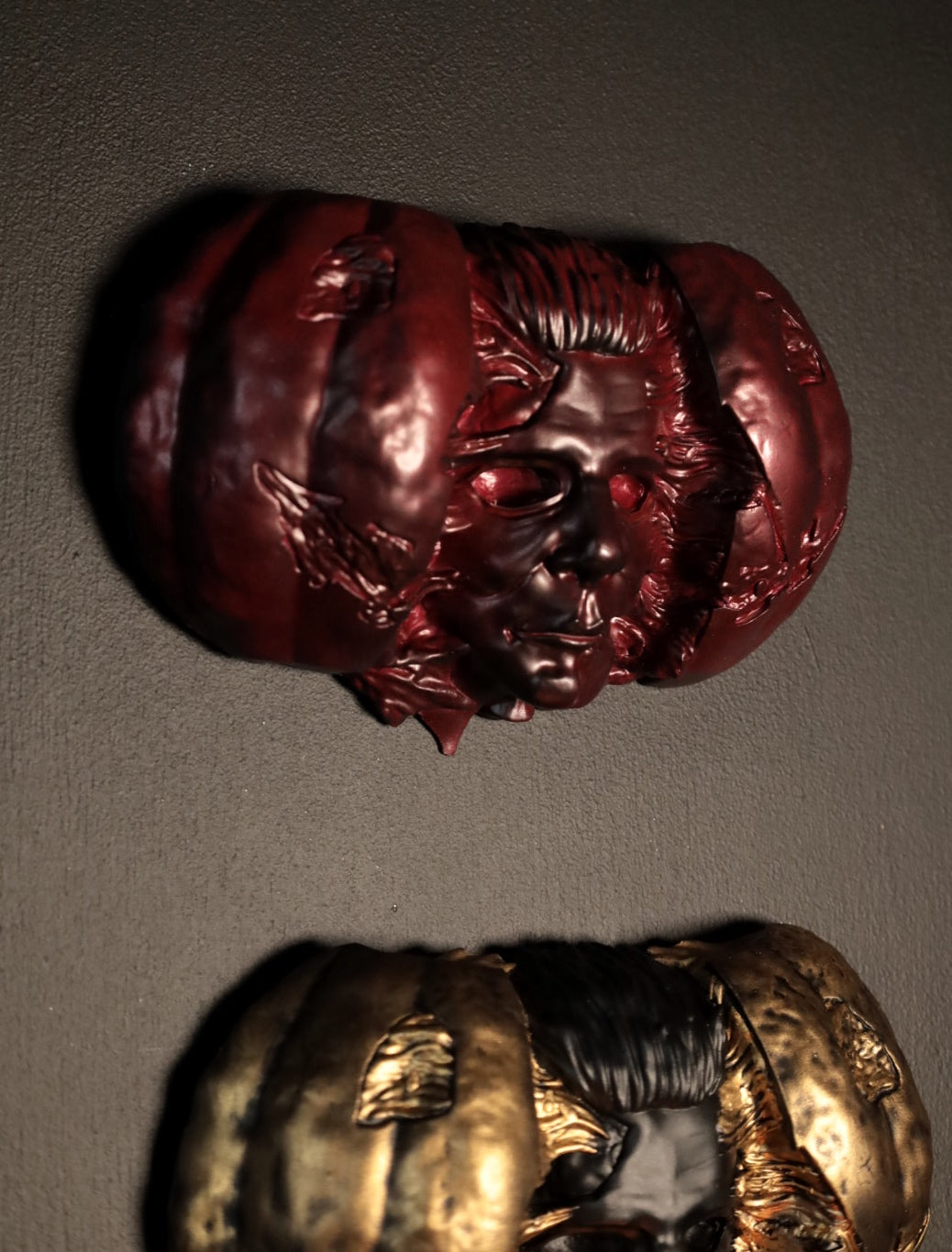 Hand holding a Halloween pumpkin with a Michael Myers face mask inside against a dark background