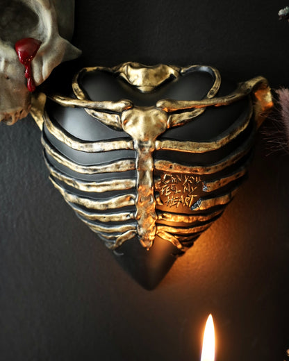 Gothic style wall decor for your gothic gallery wall shaped like a ribcage over a heart, featuring a black and gold metallic finish.
