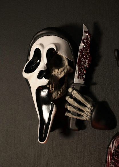 Scream Ghostface mask with a knife and hand holding it against a dark background