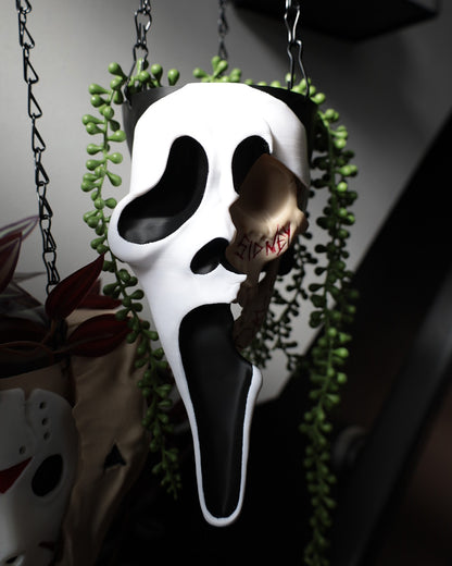 Scream ghostface planter with green plants hanging from the roof