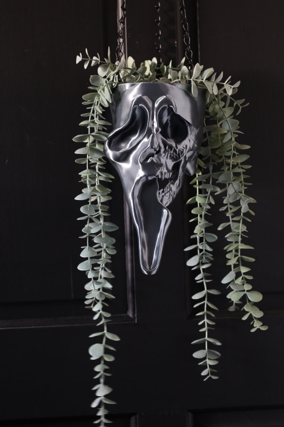 Sliver ghostface hanging planter from scream on a black background for a horror home 