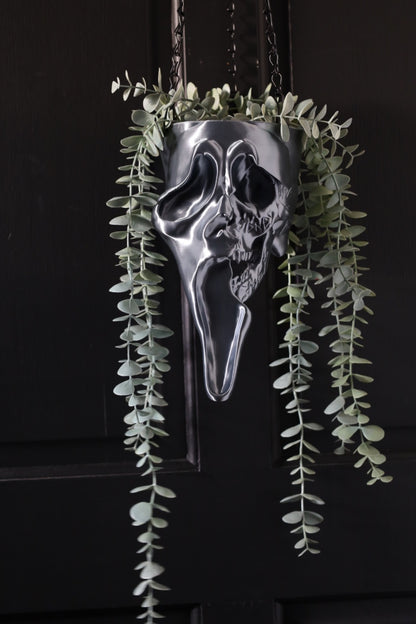 Sliver ghostface hanging planter from scream on a black background for a horror home 