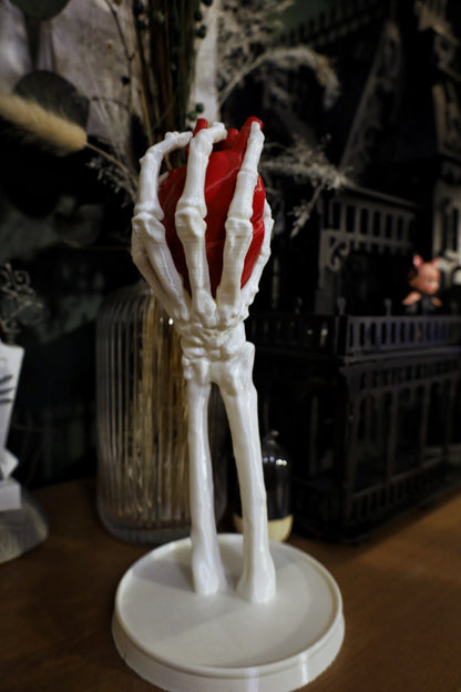 A skeleton hand jewellery stand/ornament holding an anatomical heart, gothic home decor