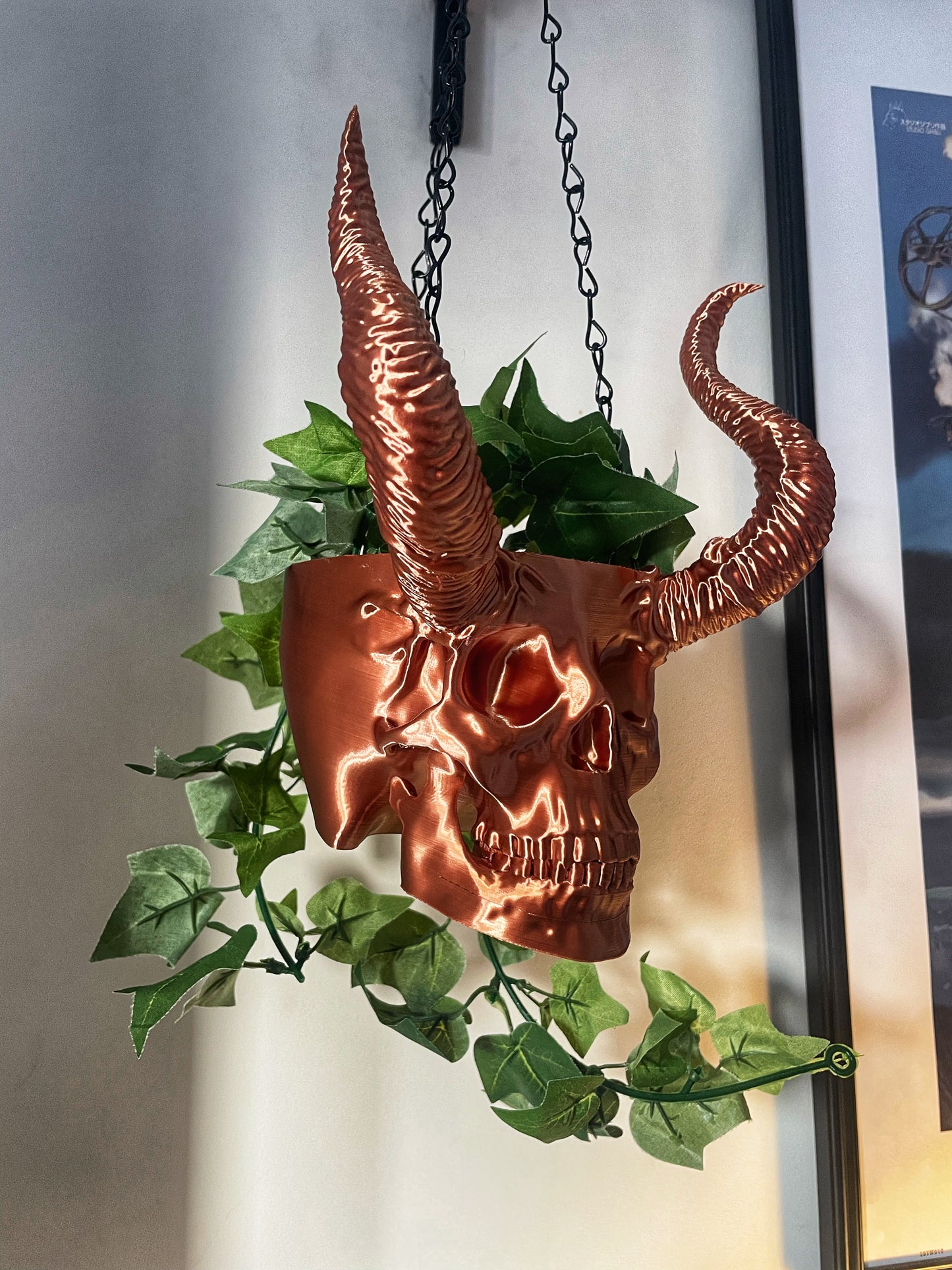 Skull with horned planter with green plants coming out of it 