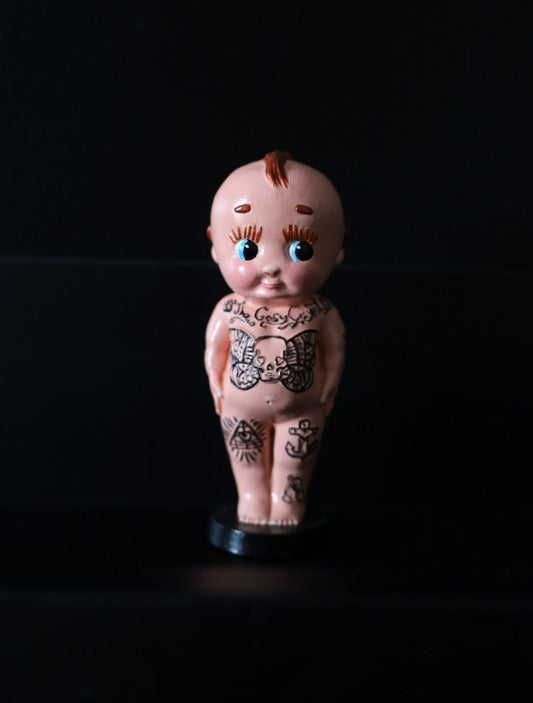 A tattooed kewpie style ornament.